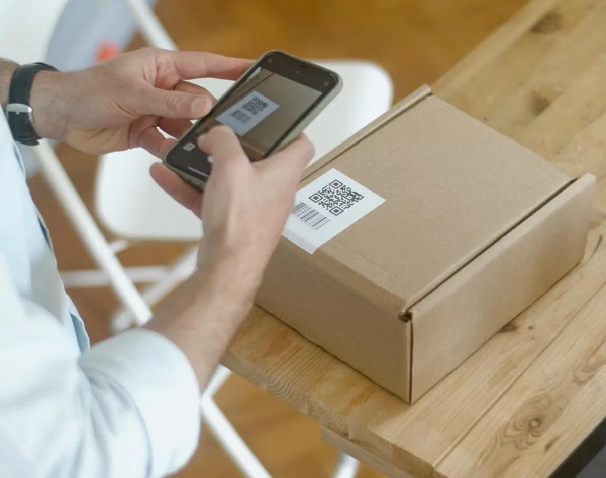 Scanning the label on a parcel with a phone before it ships.