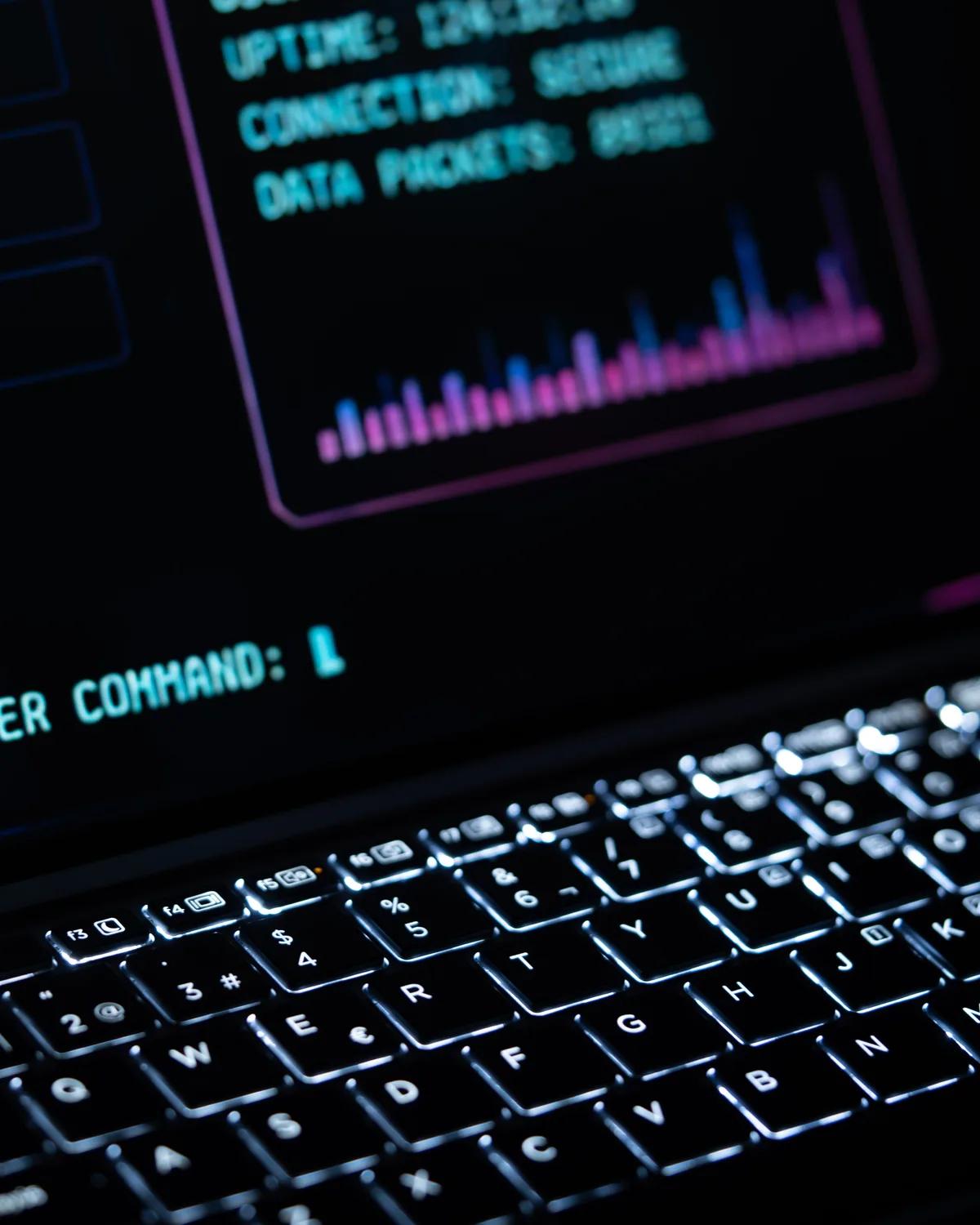 A laptop in a dark room showing a console with connection status and a command prompt, the view during an investigation.