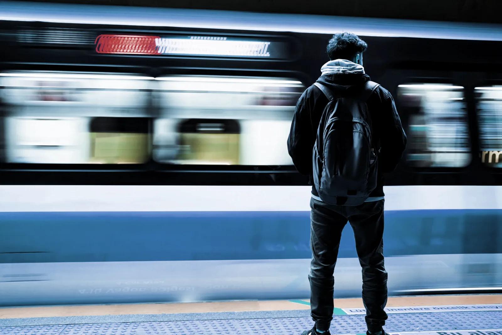 A person standing on a subway platform, representing everyday digital privacy.
